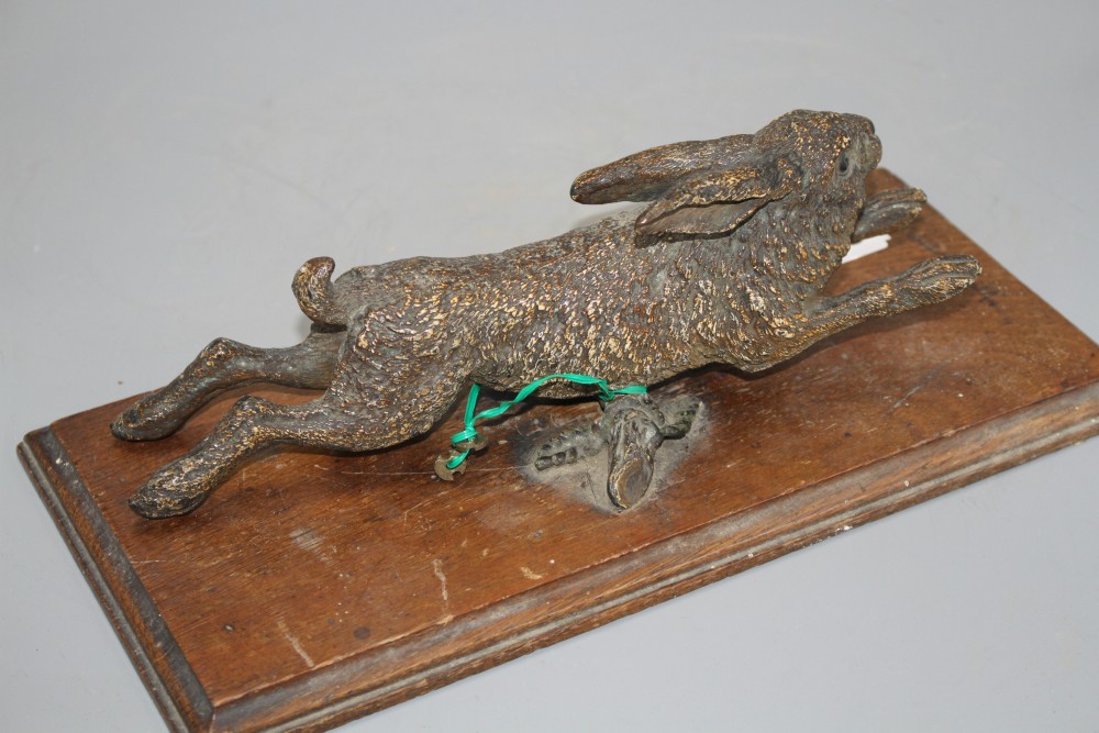 An Austrian cold painted door knocker modelled as a running hare, with oak mount, overall length 30cm, width 14cm, length of hare 25cm